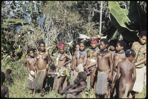 Bride price for Aina: payment observed by group of children and young women, some wearing elaborate headdresses and other ornaments