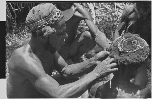 Pig festival, wig ritual: wig frame is fastened to hair