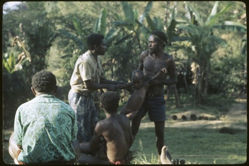 Local court case, child being pulled by men during a dispute over child's place between two groups