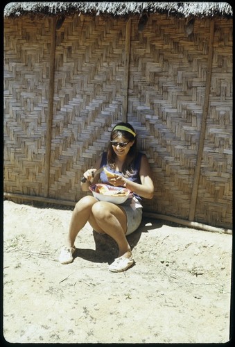 Susan Pflanz-Cook in front of woven house wall