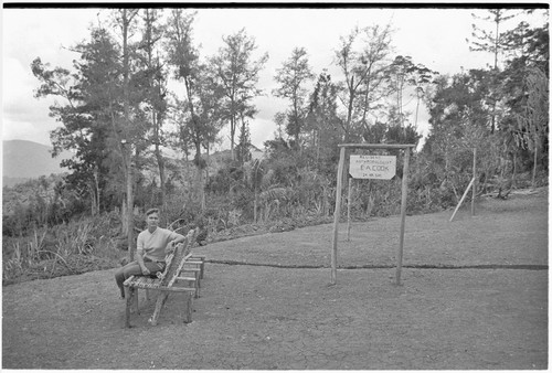 Nancy Cook next to sign: Resident Anthropologist, E.A. Cook, 24 Hr. Svc