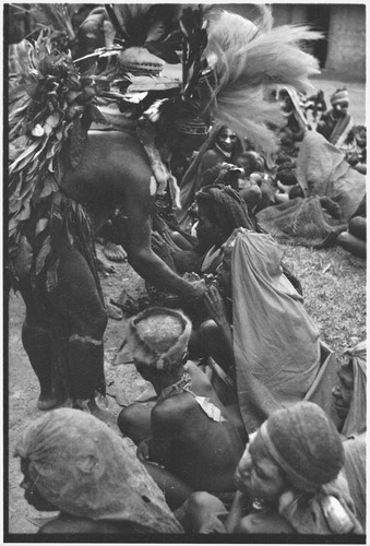 Bride price ritual: bride's kin are fed pork by man from groom's family