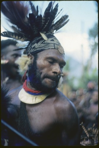 Pig festival, pig sacrifice, Kwiop: man, wearing luluai badge, performs ritual aggression