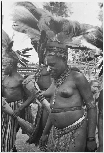 Pig festival, wig ritual: decorated adolescent girl presentation of wigged men, ritual fence in background