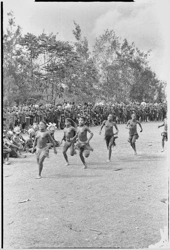 Government-sponsored festival in Tabibuga: adolescent girls run race, watched by large crowd including luluais