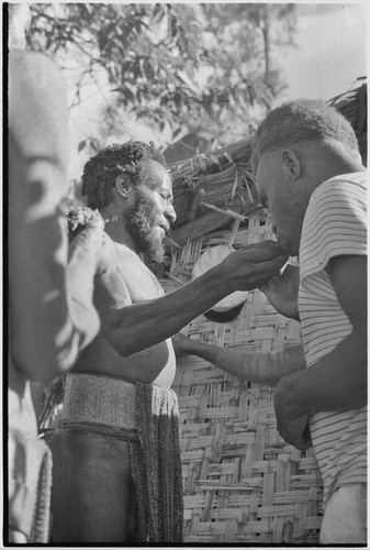 Returned laborers, purification ritual: man eats bespelled pork and yams, renouncing taboo