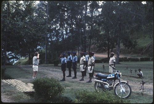 Police and other government employees in uniform lined up in front of patrol officer, Tabibuga