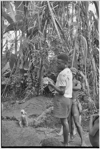 Returned laborers, purification ritual: man who has returned from contract labor holds a piglet for sacrifice to the ancestors