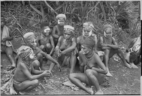 Courtship: adolescent girls on their way to Kwiop for courtship event, they wear jewelry, marsupial fur caps, talcum powder on faces