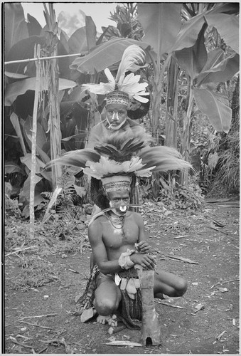 Pig festival, wig ritual: decorated men with large feather headdresses, face paint