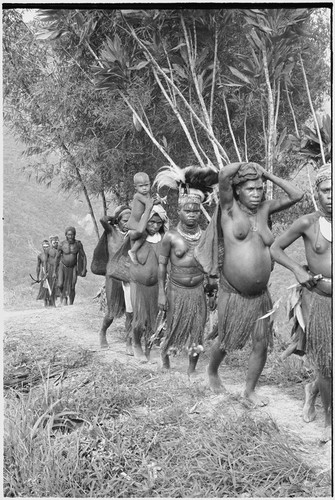 Bride price ritual: procession, including bride with headdress, on trail