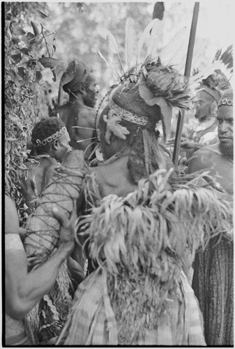 Pig festival, pig sacrifice, Kompiai: war allies at ritual fence, man on left holds bundle of salted pork