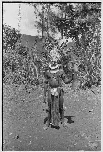 Pig festival, singsing: Wando, wearing eagle feather headdress, holds a drum