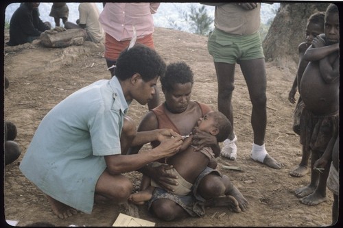 Maternal and child health clinic: health care worker gives injection to a small child