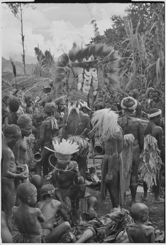 Bride price ritual: people surround payment banner of feather and shell valuables