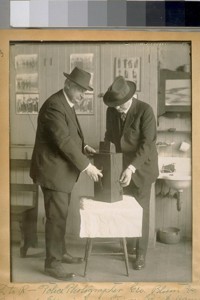 L. to R. Police Photographers Geo. Blum and Det. Serg. A. Jewel examining a finger print camera. Mar. 1922