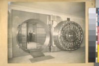 [Man standing inside bank vault]