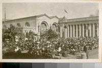 P.P.I. Ex. [Panama-Pacific International Exposition] 1915. [People seated on benches near the entrance.]