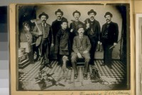 China Town Squad, San Francisco, L. to R.: Standing, P. Herrin, D. Campbell, D. Lyons, A. Say, M. Griffin, Dong Gong, Chinese Interpreter & Sergt. Jas. Donovan, Opium Pipe & Layout on the floor, about 1900