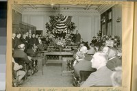 Judge McAter [McAteer] taking office as a Police Judge at the Hall of Justice Aug. 2nd, 1920. Standing under the flags, left to right: Judges Owen, Sullivan, Oppenheim, McAter [McAteer], Fitzpatrick. Chief White and [?] in the Mayor's office