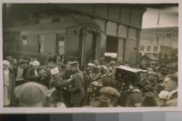 King Albert of Belgium as he arrived at the Oakland Mole. A Red Cross girl pining [sic] a rose on him