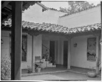 Leo V. Youngworth residence, view of porch with plants, chair, and posters, Baldwin Hills, 1932