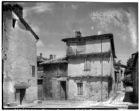 Three story building in a community of closely built buildings and narrow streets, Maisse, France, 1929