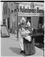 Woman and girl holding a baby in front of a hotel cafe, Volendam, Netherlands, 1929