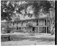 Rancho Los Cerritos, view from south-east of decaying house, balcony, walkway, and grounds, Long Beach, 1930