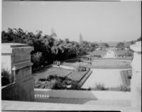 View from a terrace at the Jardin d'Essais towards a pool and people on a long promenade, Algiers, 1929