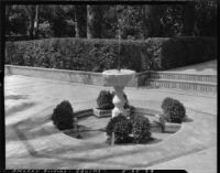 Gardens at Alcázar of Seville, view of a fountain on a paved walkway, Seville, Spain, 1929