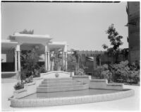 Decorative tiled pool in a courtyard in front of a pergola and next to a collective housing building, Paris, France, 1929