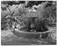 Avila Adobe, view of patio with fountain and woman with watering can, Olvera Street, Los Angeles, 1934