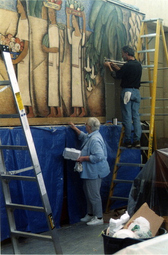 Brad Wright and Ellie Schmidt continue the restoration work on the El Dia del Mercado mural by Alfredo Ramos Martinez on site at the Coronado Public Library, Coronado, 2005