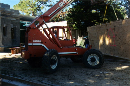 A telescopic forklift loader is used to move the five crates containing the restored El Dia del Mercado mural by Alfredo Ramos Martinez across the construction area and into the Coronado Library, 2005