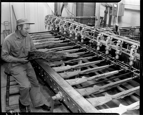 Man by milling machine that shapes wooden rifle stocks