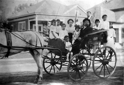 Close up of carriage with Tom Shee Bin, wife, and family. From right to left: Harriet,--, Ora, Sun, Tom Second from left: Gerald First on left: Gladys