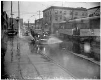Automobile drives through flooding on Hill St., Los Angeles, December 1937
