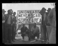 Group of men standing next to "union labor" sign during 1937 motion picture industry strike