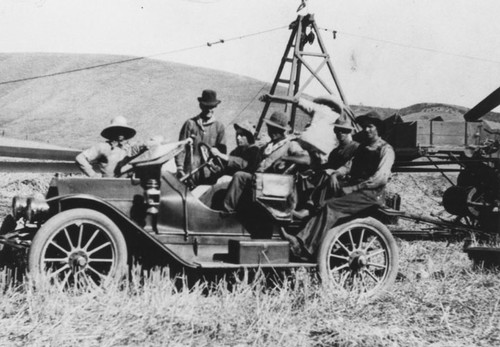 Farm workers in automobile in the field