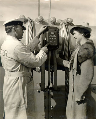 [Sam Conway, roadside service man on the San Francisco-Oakland Bay Bridge, showing an emergency call-box to Marian Conway]