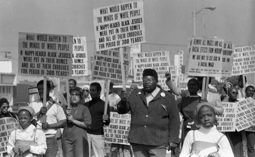 Protesters holding signs during a parade, Los Angeles, 1982