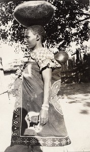 A young woman carrying a child on her back