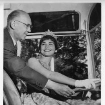 Linda Marie Hines, Miss Sacramento, wearing tiara, at steering wheel of a bus with an unidentified man