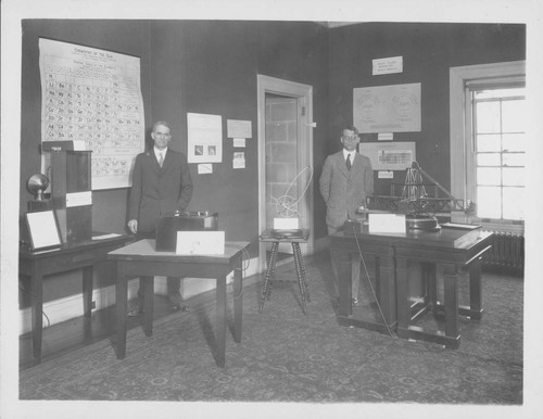 Walter S. Adams and Paul W. Merrill, standing with four displays at the Mount Wilson Observatory exhibits area