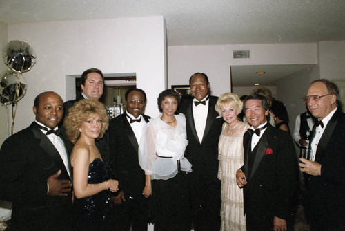 Iris Rideaux and Tom Bradley posing with others at a fundraiser, Los Angeles, 1986
