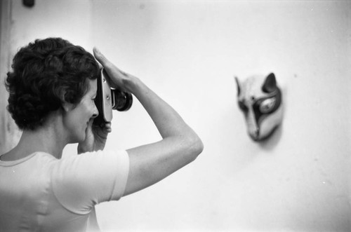 Woman photographing a mask, Barranquilla, Colombia, 1977
