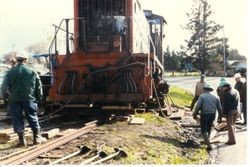 Workmen are removing the P&SR railroad tracks on South Gravenstein Highway 116 near Industrial Avenue and Sparkes Road, about 1984 with the help of a Southern Pacific engine