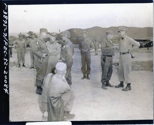 General J. Lawton Collins and others confer at airstrip