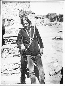 Navajo Indian man wearing large silver earrings, and wampum necklace, ca.1900